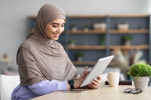 Someone using a tablet to have an online counseling session with a therapist.