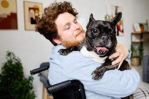 A person with PTSD holding a support dog.