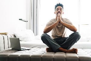 Person Sitting On Bed Meditating